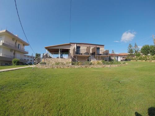 uma casa com um campo de relva em frente em Kimiro Drosia Zante em Psarou