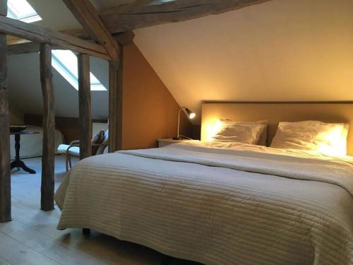 a bedroom with a large bed in a attic at BenB La Fosse Bleue in Signy-lʼAbbaye