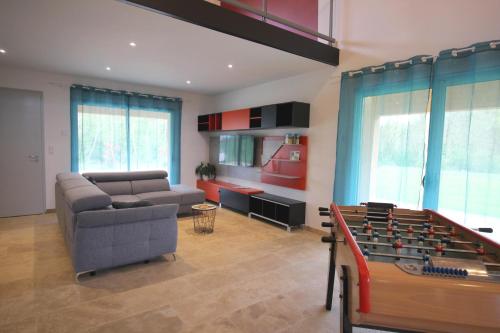 ein Wohnzimmer mit Sofa und Tischfußball in der Unterkunft Gite de L'Enclos in Lavardens