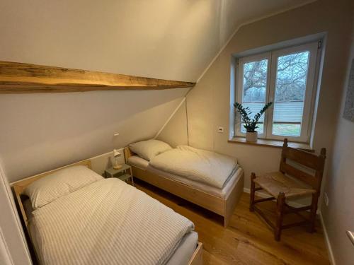 a room with two beds and a chair and a window at Ferienhaus Mein Stall in Borken