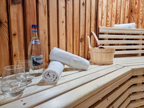 a wooden table with a bottle of beer and towels at Vila Victoria Moldovița in Moldoviţa
