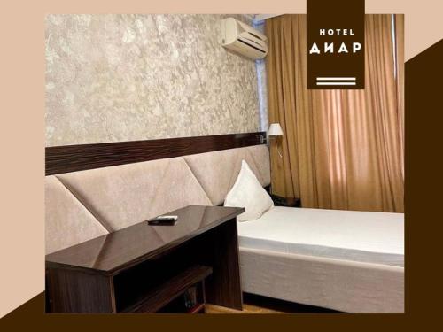 ein Hotelzimmer mit einem Bett und einem Schreibtisch in der Unterkunft Diar in Atyrau
