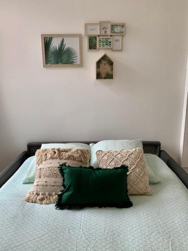 a bed with pillows on it in a bedroom at Florimond cosy apparts in Saint-Quentin