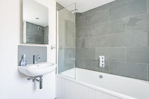 a bathroom with a sink and a tub and a shower at Liberty Cottage in Broadstairs