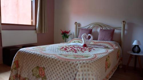 - une chambre avec un lit avec un animal rembourré dans l'établissement Chalés Mimar Lumiar Suítes individuais, à Lumiar