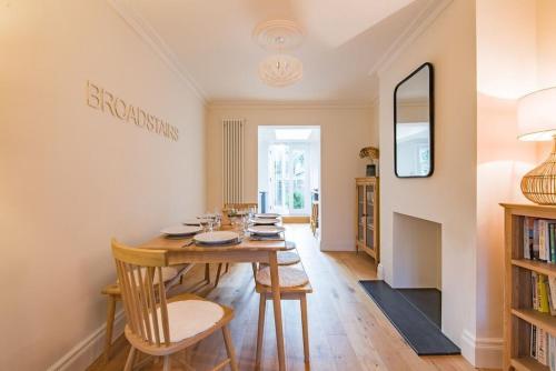 a dining room with a wooden table and chairs at Liberty Cottage in Broadstairs