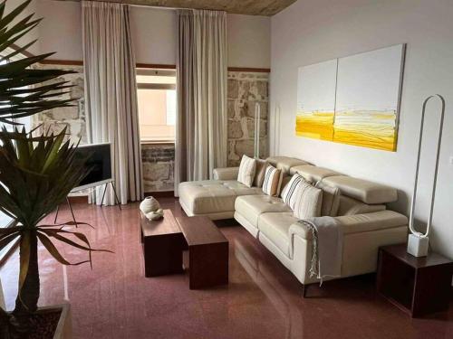 uma sala de estar com um sofá e uma mesa em Luxury Beachfront Apartment Las Canteras em Las Palmas de Gran Canaria