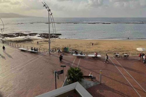 uma vista para uma praia com pessoas andando na areia em Luxury Beachfront Apartment Las Canteras em Las Palmas de Gran Canaria