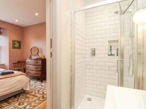 a bathroom with a shower and a bedroom at Treveddoe Farmhouse in Bodmin