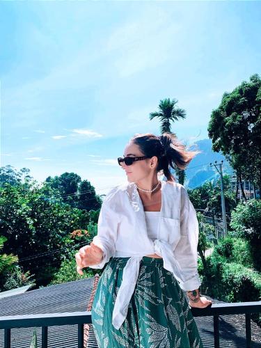 a woman wearing a white shirt and a green skirt at Poomaz Peace Palace in Ella