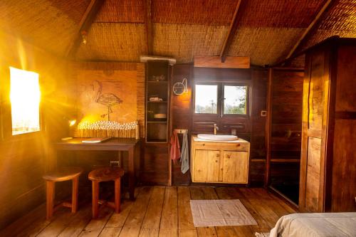 a room with a bed and a table and stool at Mansa Musso Treehouse Resort in Sanyang