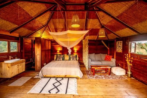 Mansa Musso Treehouse Resort في Sanyang: غرفة نوم بسرير واريكة في غرفة