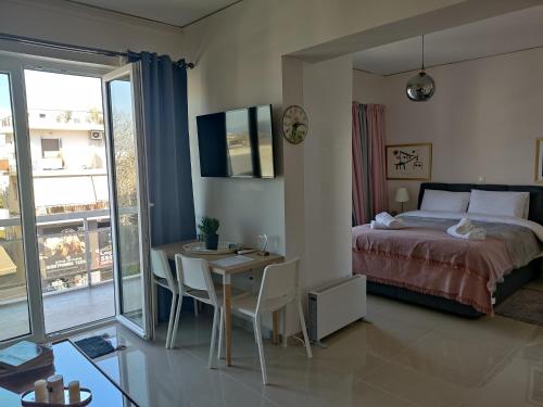Schlafzimmer mit einem Bett und einem Schreibtisch sowie einem Tisch mit Stühlen in der Unterkunft Διαμέρισμα studioJoy4stay στο Χαλάνδρι in Athen