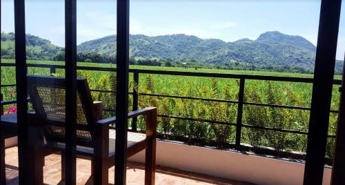 a balcony with a chair and a view of the mountains at Takimi Mini Villa in Wellawaya