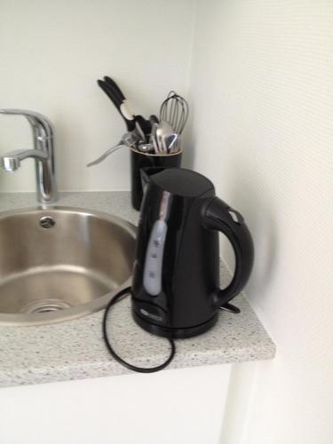eine schwarze Kaffeemaschine auf einer Theke neben einem Waschbecken in der Unterkunft 12 Torvegade. 1 door 4. (id.154) in Esbjerg