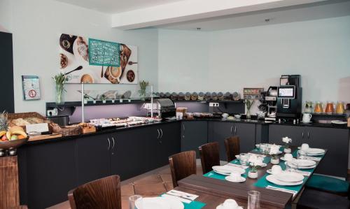 a restaurant with a table with chairs and a counter at Friends Hotel Kerpen in Kerpen