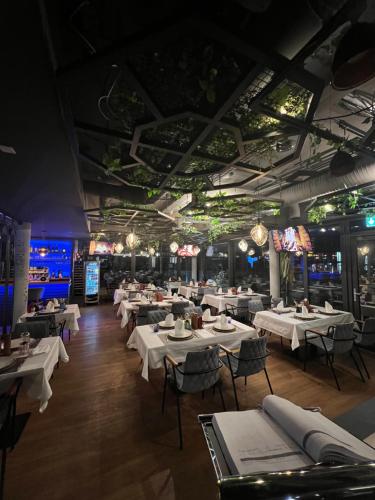 a dining room with white tables and chairs at Design Hotel Winterrot in Karlsruhe