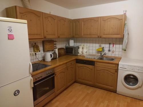 una cucina con armadi in legno e frigorifero bianco di Ferienwohnung in Arzberg 1 ad Arzberg