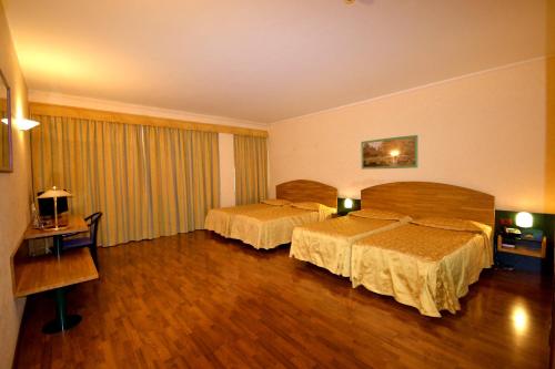 Ένα ή περισσότερα κρεβάτια σε δωμάτιο στο Sun Hotel