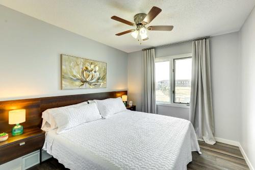 a bedroom with a white bed and a ceiling fan at Pet-Friendly Omaha Vacation Rental with Deck! in Omaha