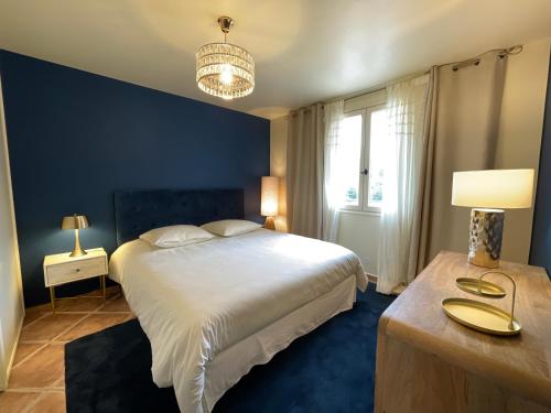 1 dormitorio con 1 cama grande y pared azul en O' Cocooning - Appart dans Bastide proche Aix, en Rousset