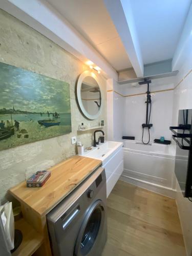 une salle de bain avec une machine à laver et un lavabo dans l'établissement L’inattendu, à Uzès