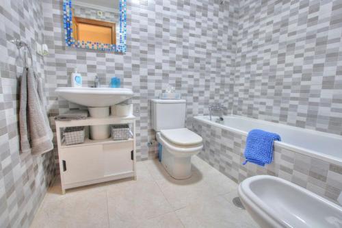 a bathroom with a sink and a toilet and a tub at Parque Playa, in the heart of La Cala de Mijas. in La Cala de Mijas