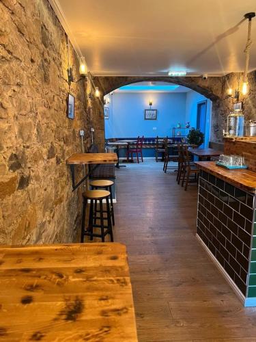 a restaurant with tables and chairs and a stone wall at SMITH PLACE HOTEL in Edinburgh