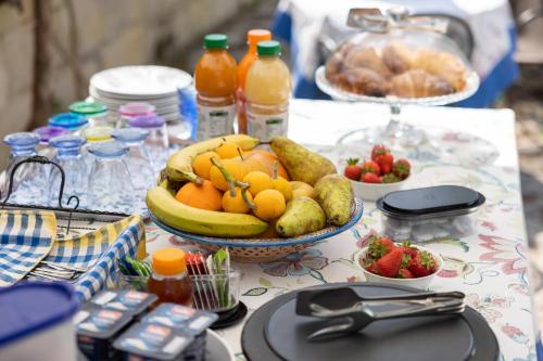 a table with a bowl of fruit and bottles of juice at Casa Ulmi con piscina in Uggiano la Chiesa