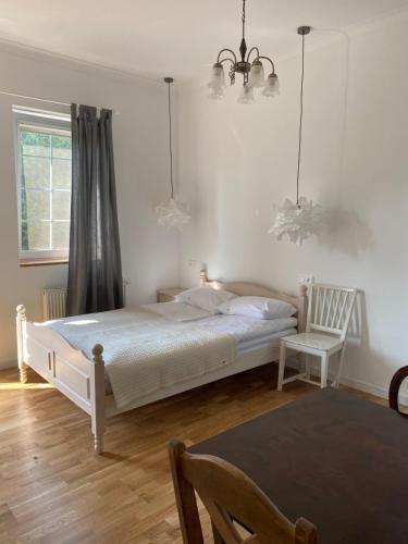 a bedroom with a bed and a chair and a window at GOŚCINIEC STRZECHA in Kąty Rybackie