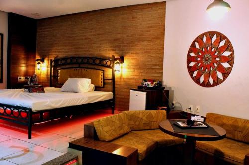 um quarto de hotel com uma cama e um sofá em MOTEL COPACABANA em Ribeirão Preto