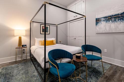 a bedroom with a bed and two blue chairs at The St. Louis in New Orleans