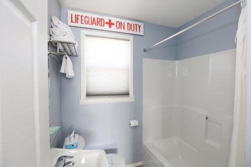 a bathroom with a white toilet and a sign on the wall at The Southwinds in Cape May