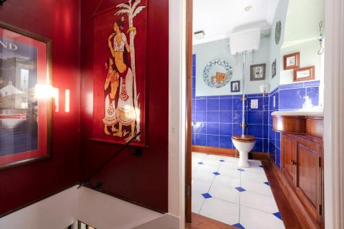 a bathroom with a toilet and a red wall at Strathendrick House Magnificent property with Garden in Drymen