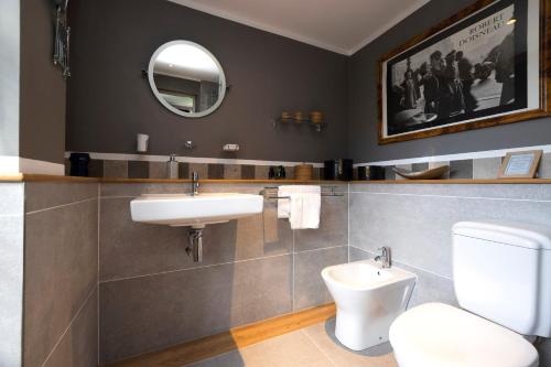a bathroom with a sink and a toilet and a mirror at Strathendrick House Magnificent property with Garden in Drymen