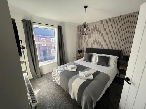 um quarto com uma cama com duas toalhas em Centrally located in city of Lincoln Idas Place - two bedrooms each with a kingsize bed em Lincolnshire