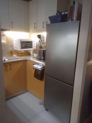 a kitchen with a stainless steel refrigerator in it at McKinley Hills BGC Taguig City Condo in Manila