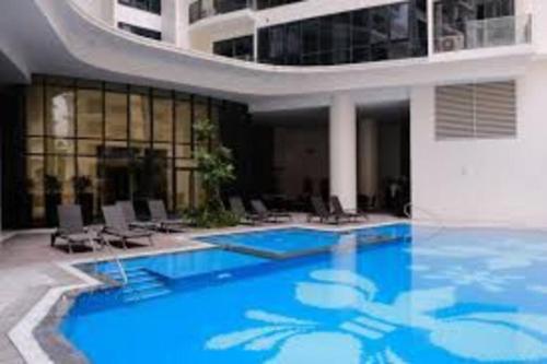 a large swimming pool with chairs and a building at McKinley Hills BGC Taguig City Condo in Manila