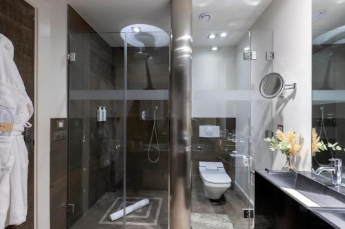 a bathroom with a toilet and a glass shower at Hospes Palacio del Bailio, a Member of Design Hotels in Córdoba