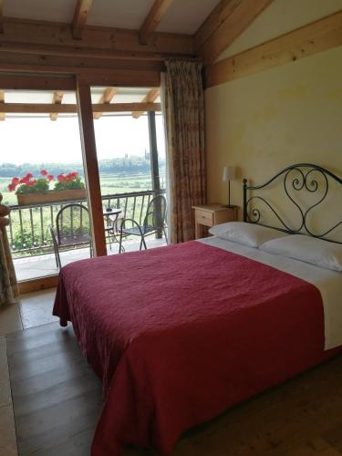 a bedroom with a large bed and a balcony at Costa degli Ulivi in Fumane