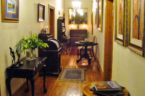 a living room with a piano and a table at Ladismith Manor in Ladismith