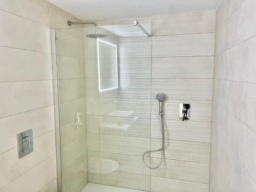een douche met een glazen deur in de badkamer bij Apartamento Cala Ratjada. Recién reformado in Cala Ratjada