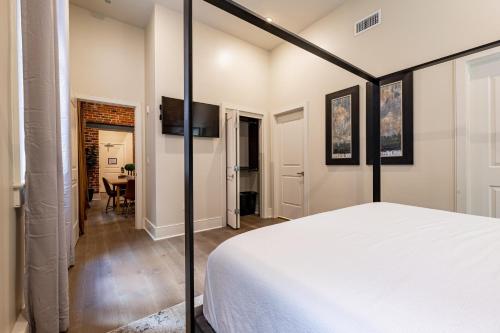 een slaapkamer met een wit bed en een eetkamer bij The Audubon in New Orleans