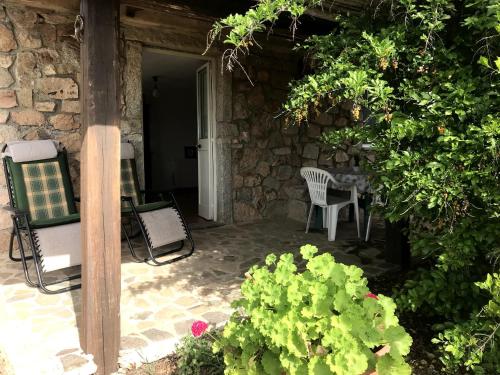 un patio con 2 sillas, una mesa y una mesa y algunas plantas en Villa Ederle en La Maddalena