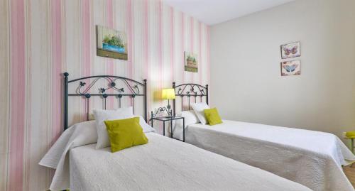 two beds in a room with pink and white stripes at La Lancha in El Torno