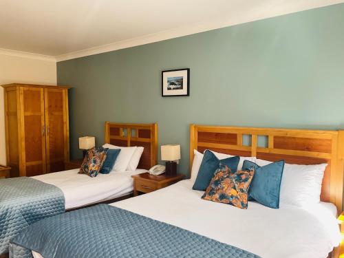 a bedroom with two beds with blue and white pillows at Hotel Newport in Newport