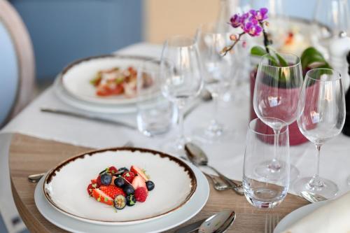 a table with plates of food and wine glasses at Mövenpick Balaland Resort Lake Balaton in Szántód