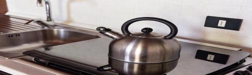 a tea kettle sitting on a stove in a kitchen at Antiqua Vallis in Palaia