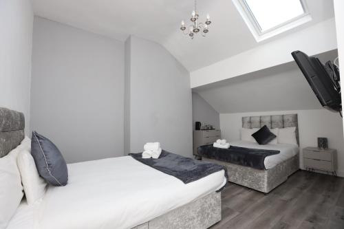 1 dormitorio con 2 camas y lámpara de araña en Hotel Anfield, en Liverpool