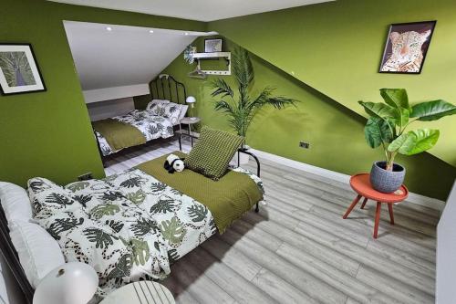 a bedroom with green walls with a bed and plants at Manchester, Rusholme, UK with free parking in Manchester